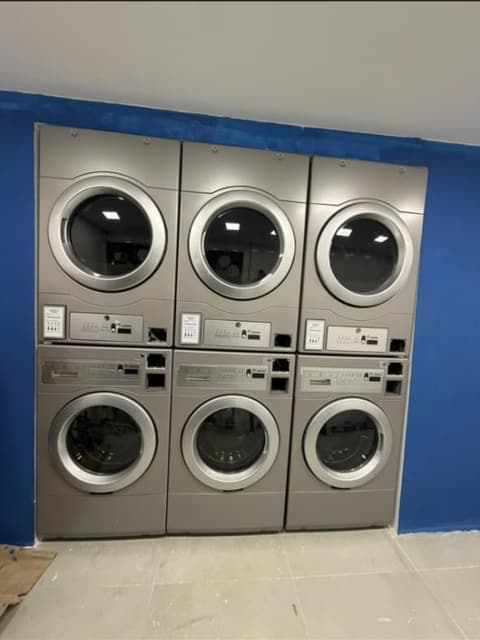 Seis máquinas profissionais empilhadas e embutidas numa parede azul